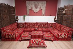 an ornately decorated living room with red couches and rugs on the floor