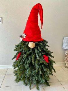 an elf's hat on top of a christmas tree in the middle of a room