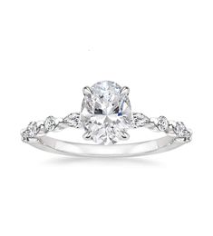 a white gold engagement ring with an oval cut diamond in the center and side stones