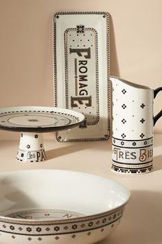 two plates and a bowl on a table next to a tray with an empty plate