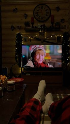 a person laying on the floor in front of a flat screen tv with christmas lights