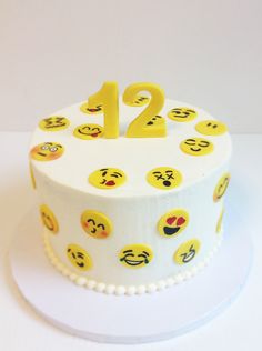 a white cake topped with lots of smiley faces on it's sides and the number twenty two