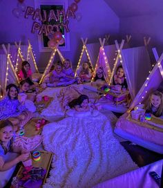 a group of children laying on top of a bed in a room filled with lights