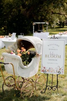 an old fashioned baby carriage with flowers in it and a welcome sign on the back