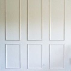 a white toilet sitting next to a wall with paneling on it's sides