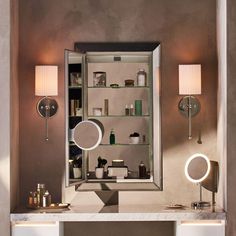 a bathroom vanity with two lights and a mirror on the wall next to it,