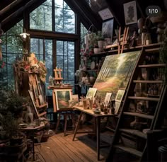 an artist's studio with lots of paintings and plants