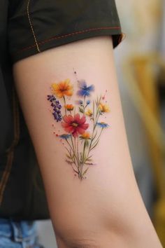 a woman's arm with colorful flowers on the left side of her body,