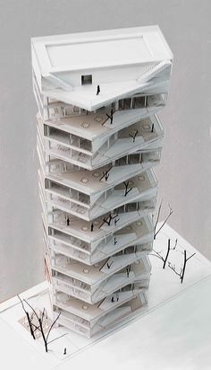 a tall white building sitting on top of a snow covered ground in front of a tree