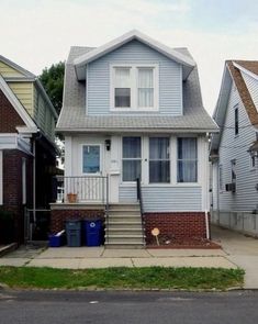 two story house with stairs leading to the front door