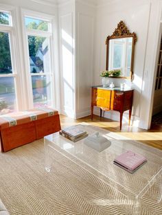 a living room filled with furniture and windows next to a table on top of a rug