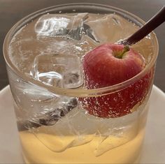 an apple in a glass with ice and water