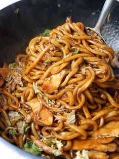 a bowl filled with noodles and meat on top of a table