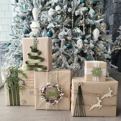 several wrapped presents sitting in front of a christmas tree