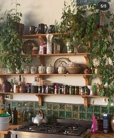 the kitchen has many pots and pans on the shelves above the gas stove,