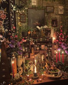 a room filled with lots of different types of flowers and candles on top of a table