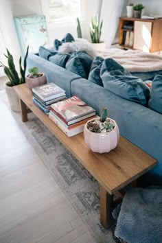 a living room with a blue couch and books on the coffee table