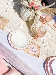 there is a table with seashells and flowers on it