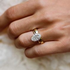 a woman's hand with a diamond ring on top of her finger and an engagement band