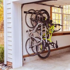 there is a bike hanging on the wall next to it's bicycle storage rack