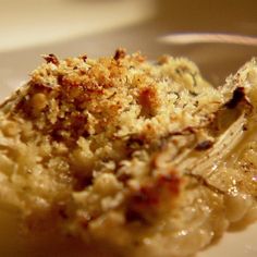 a close up of food on a plate with broccoli florets and bread crumbs