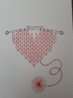 a piece of paper with red thread on it and an arrow drawn in the middle