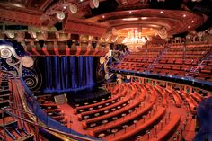 an auditorium with red seats and blue curtains