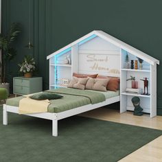 a bedroom with green walls and white furniture