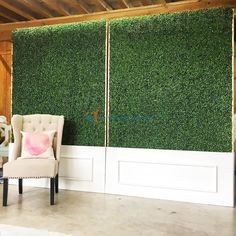 a chair sitting in front of a wall covered with green grass and two white doors