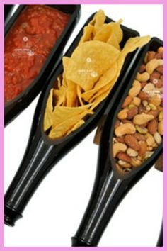 three black serving spoons filled with different types of food and beans on top of each other