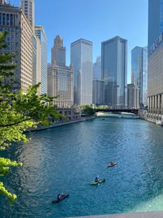 several people are kayaking down a river in the city