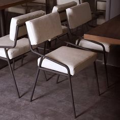 a row of chairs sitting next to each other in front of a table with wine glasses on it