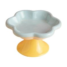 a yellow and white bowl sitting on top of a wooden stand in front of a white background