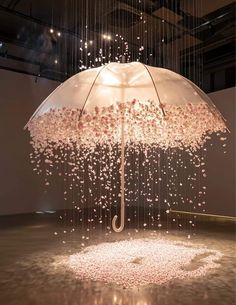 an umbrella that is floating in the air with pink flowers on it and rain drops falling down