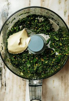 a food processor filled with greens and butter