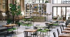 an empty restaurant with green chairs and tables