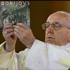 an older man holding up a book in front of his face