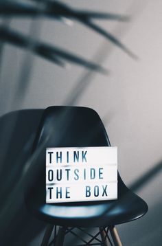 a black chair with a sign that says think outside the box