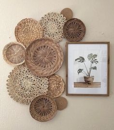 there are many wicker baskets on the wall with a potted plant next to it