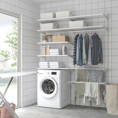 a washer sitting next to a dryer in a room with tiled walls and floor