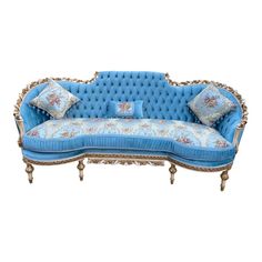 an old fashioned blue couch with pillows on it's back and arms, sitting in front of a white background