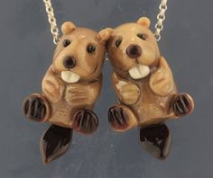 two brown bears sitting on their hind legs holding each other's paws and touching noses