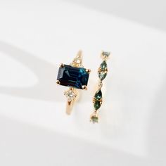 a pair of earrings with blue and green stones on white background, close up view