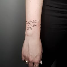 a woman's arm with an arrow tattoo on the left side of her wrist