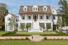 a large white house sitting on top of a lush green field