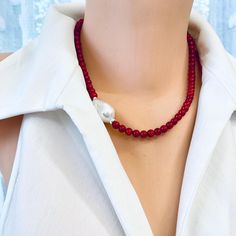 Add a splash of vibrant color to your collection with this beautiful red coral short necklace. Featuring striking red coral beads, this necklace exudes a bold, natural beauty that instantly elevates any look. A unique natural baroque pearl placed on the side adds an elegant focal point, creating a stunning contrast against the vibrant coral. Crafted with sterling silver details, this necklace has a polished, luxurious finish. At 18 inches, it sits comfortably along the neckline, making it perfec Red Coral Necklace, Coral Shorts, Coral Necklace, Coral Beads, Short Necklace, Formal Outfit, Red Coral, Baroque Pearls, Color Pop