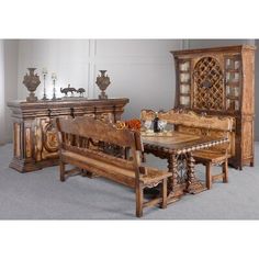 an ornately carved wooden table and bench in a room with gray carpeted flooring