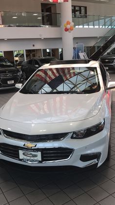 a white car is parked in a showroom