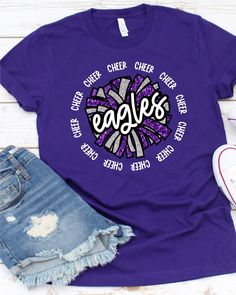 Introducing the Eagles Cheer DTF Transfer, perfect for any fan looking for a unique and high-quality design for their t-shirt! Rely on Rustic Grace, the #1 online store for heat transfer designs and vinyl transfers, to deliver a product that will exceed your expectations. Our DTF transfer process ensures that the full-color design is vibrant and long-lasting, without cracking or fading over time. Made with only the highest quality materials, these transfers are guaranteed to look great on any t- Purple Tops With Letter Print For Fan Gear, Purple Letter Print Tops For Fan Gear, Purple Graphic Print Top With Team Spirit Style, Purple Letter Print Top For Sports Fans, Purple Graphic Print Top For Team Spirit, Trendy Short Sleeve T-shirt With Glitter Print, Purple Team Spirit Graphic Print Top, Red T-shirt For Cheerleading With School Spirit, Trendy Short Sleeve Glitter Print T-shirt