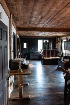 a living room filled with furniture and wooden floors next to a doorway that leads to another room